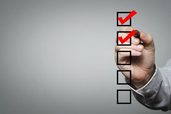 Hand marking boxes on a checklist.