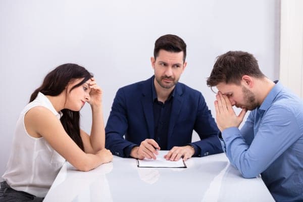 Mediator meeting with two people at a table.