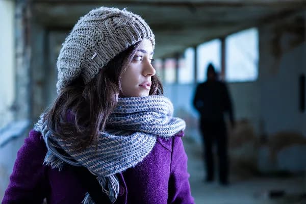 Image of a woman looking over her shoulder, symbolizing the fear and anxiety experienced by victims of stalking. Alt tag: Stalking Protective Order Requirements Explained.. What are the Requirements for Getting a Stalking Protective Order?