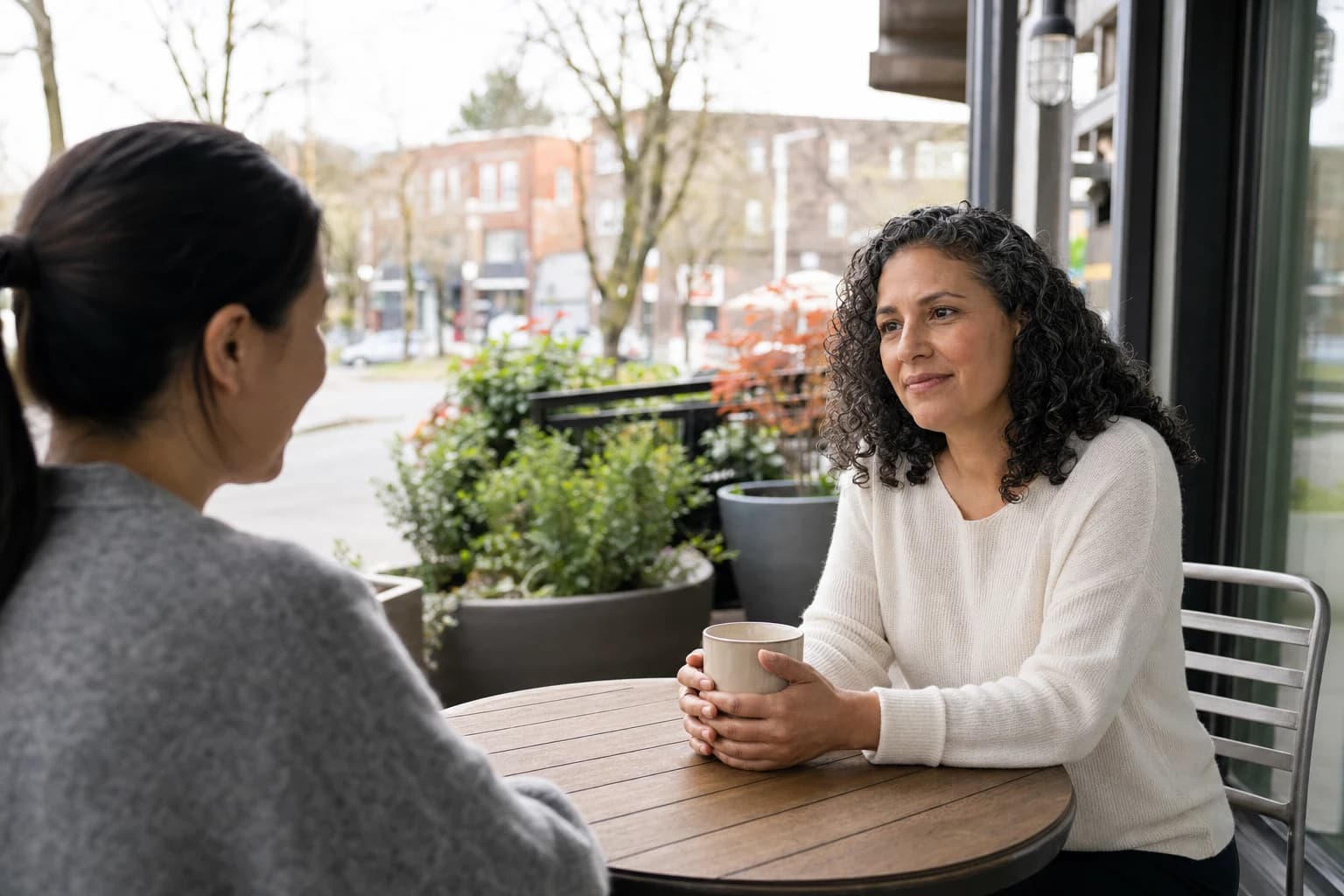 An image of a diverse group of people sitting around a table in a modern office setting, engaged in discussion. The individuals include both men and women, representing various ages and ethnicities. They appear to be reviewing documents, with one person p
